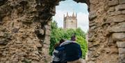 People sat on wall in architectural ruins