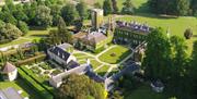 Aerial photo of a large estate with surrounding gardens, fields and trees.