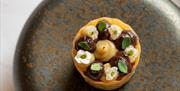A small tart on a plate with tiny flowers on it