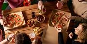 People sharing pizzas
