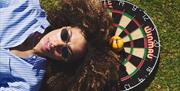 Person lying down on top of a dart board