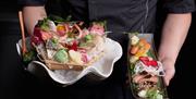 Person holding Sashimi & Nigiri sets