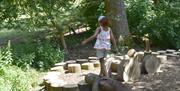 Girl on the balancing logs at Prior Park Landscape Garden