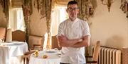 A man wearing a chef's uniform with his arms folded at the Restaurant Hywel Jones in Lucknam Park, near Bath