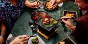 People grilling meat at Robun