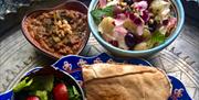 Bowls and plates of colourful Persian food decorated with small flowers