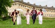 A grpoup of people wearing Regency costume at the Royal Crescent in Bath