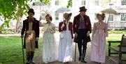 A group of people wearing Regency costume in Queen Square, Bath