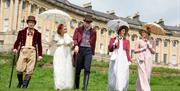 Five people walking in front of Bath's Royal Crescent wearing period dress