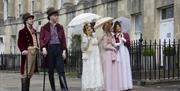 Five people walking along The Circus in Bath wearing period dress