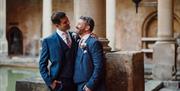 A couple smiling at each other at their wedding ceremony in The Roman Baths