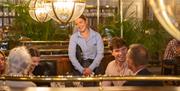 Waitress speaking to customers in restaurant booth