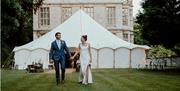 The bride and groom in front of a tent