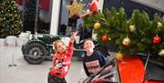 Kids pointing at elf in motor museum