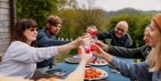 Dining outdoors and clinking glasses