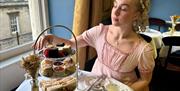 Lady having afternoon tea whilst dressed in period costume