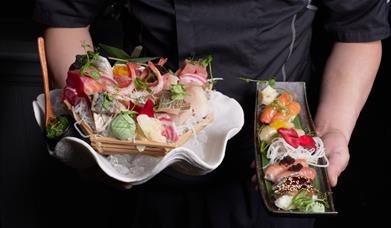 Person holding Sashimi & Nigiri sets