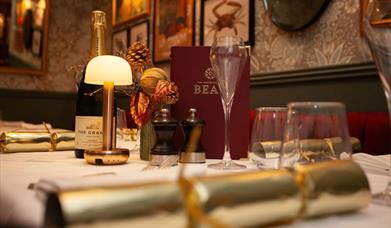 A table laid for Christmas with a cracker in the foreground at Brasserie Beau in Bath