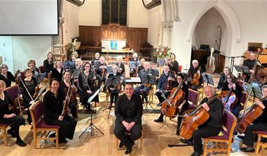 Photo of the orchestra with conductor in front