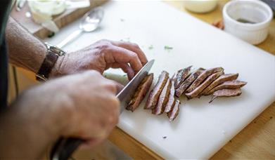 person cutting meat
