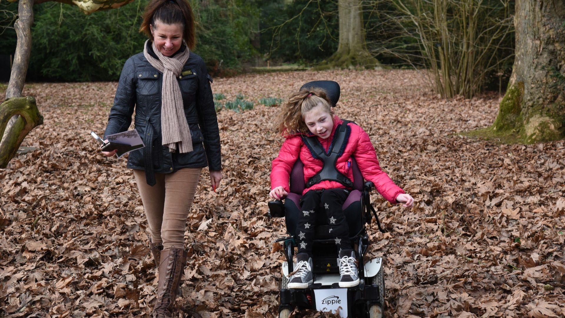 Woman and child in wheelchair in forest