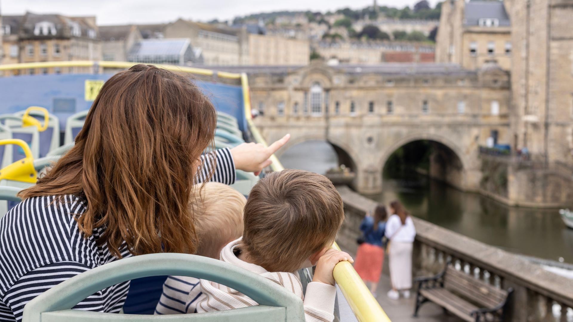 Woman and child on sightseeing open top bus in Bath