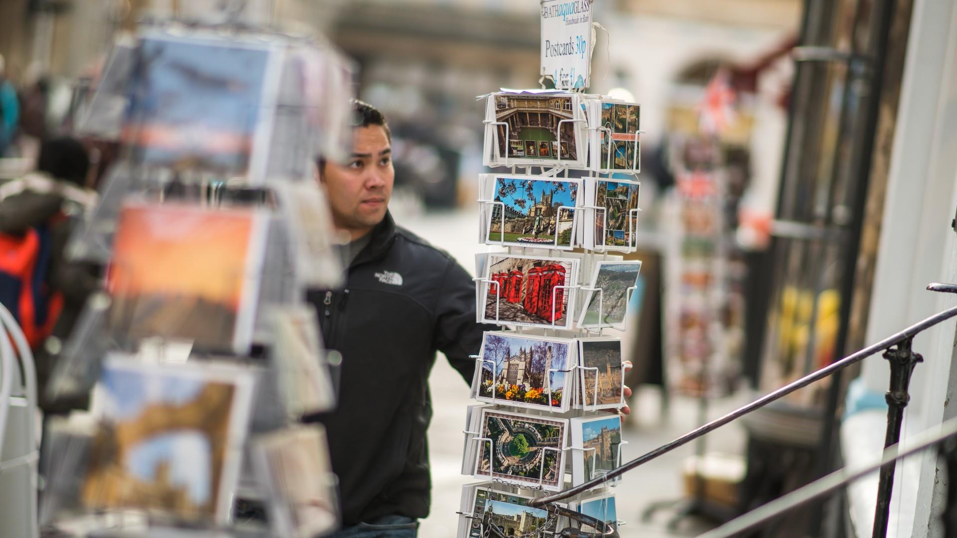 Man looks at postcard display
