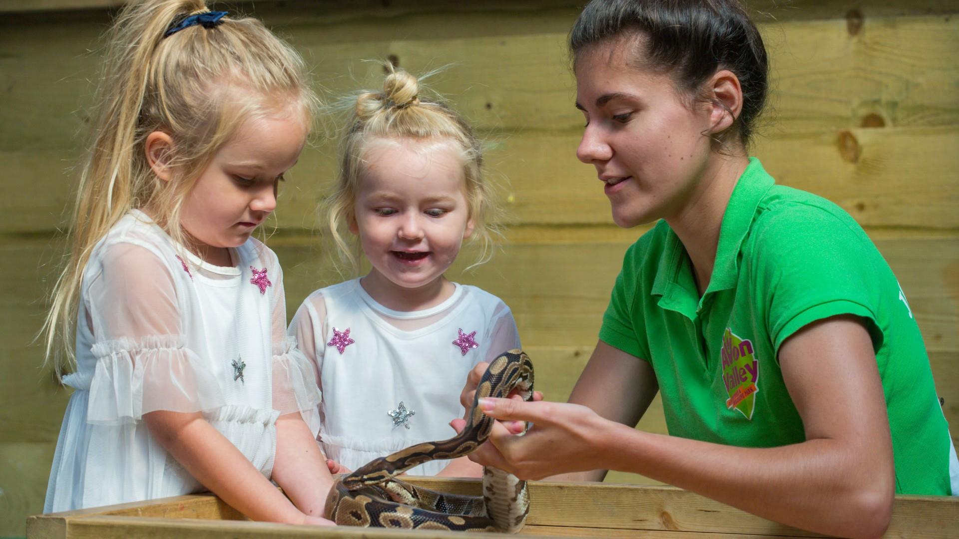 Two girls petting a snake at Avon Valley Adventure and Wildlife Park