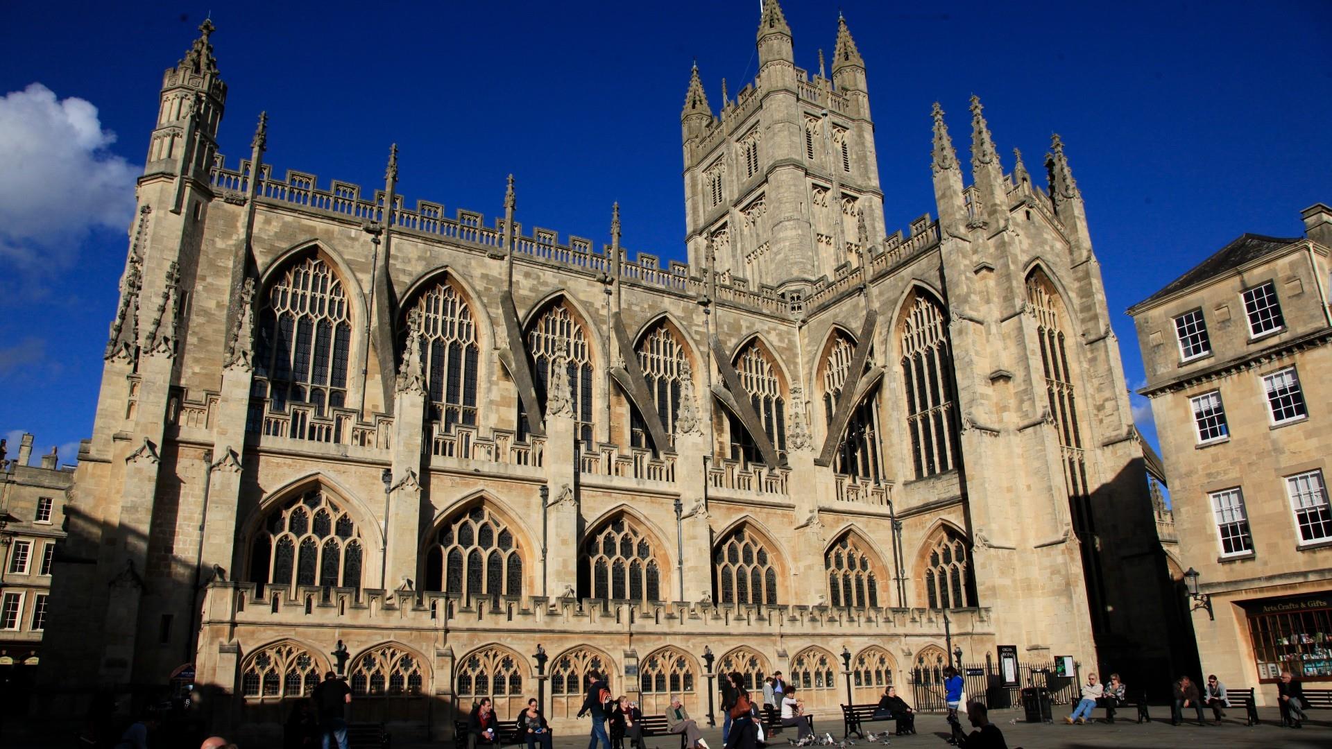 Bath Abbey surrounded by visitors and blue skies