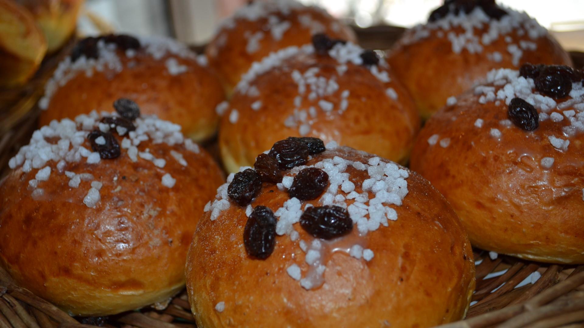 A basket of Bath Buns covered in sugar and currants