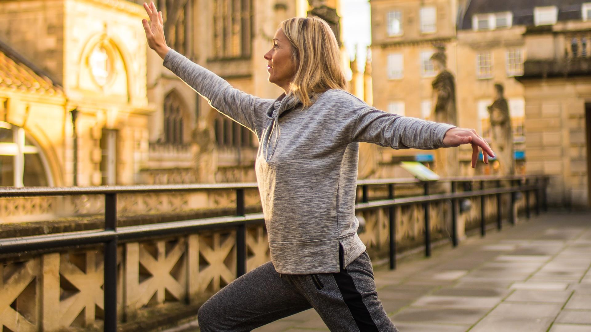 Sporty woman doing yoga in front of Bath Abbey