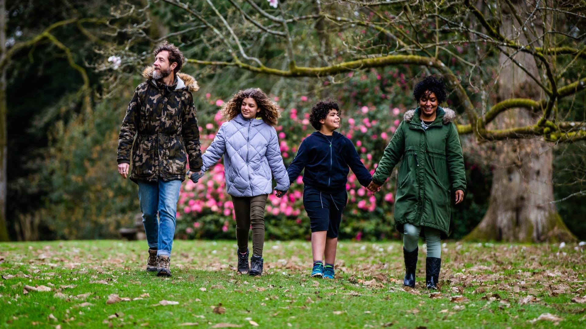 A family walking through trees at Westonbirt Arboretum, near Bath.