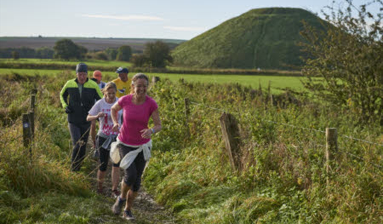 Runners taking part in the Avebury Trust 10km trail run in green countryside