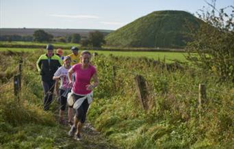Runners taking part in the Avebury Trust 10km trail run in green countryside