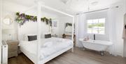 White bedroom with four poster bed