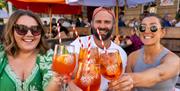 A group of friends clinking glasses of Aperol Spritz outside Green Park Brasserie