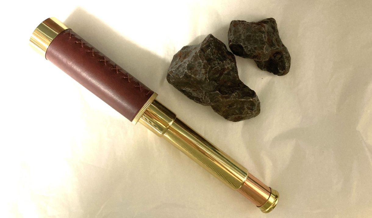 A vintage telescope and two rocks