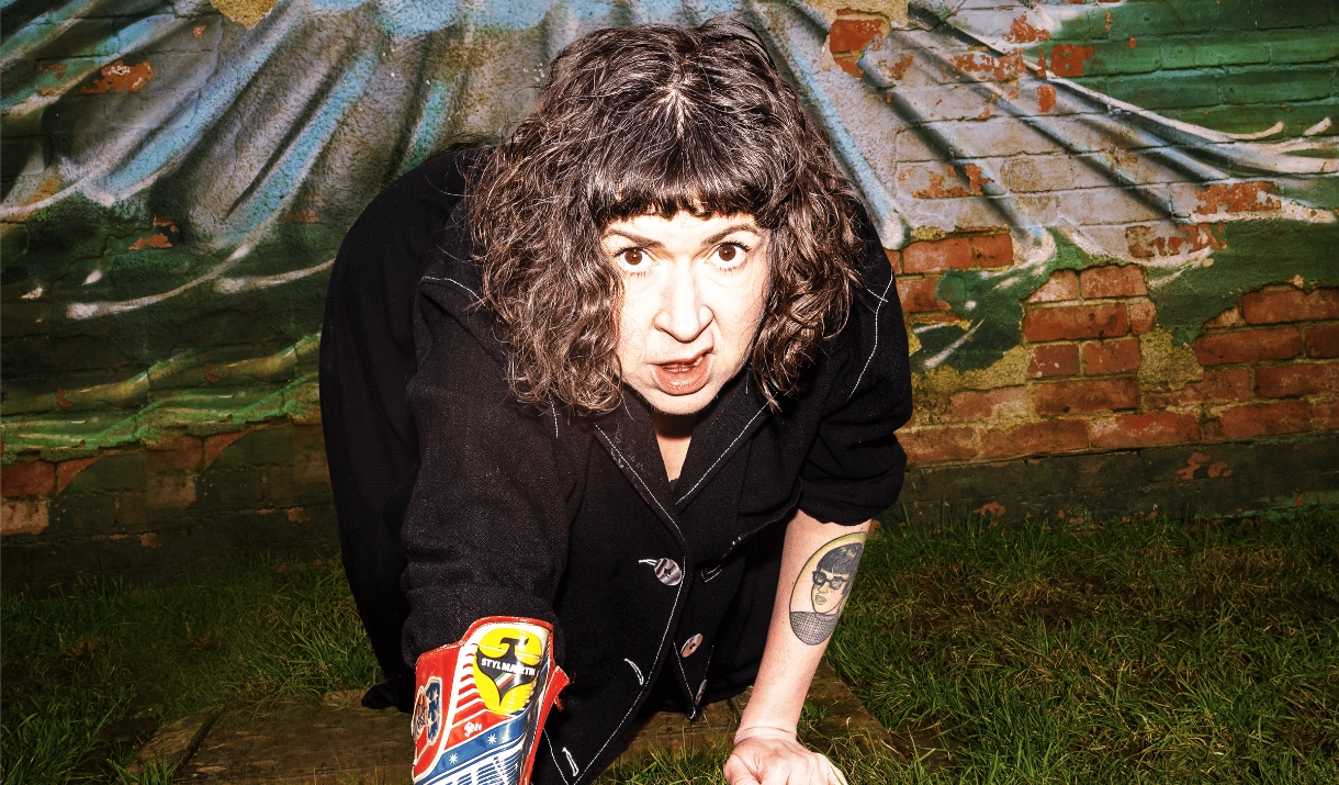 Amy Mason crawls towards the camera, she is on grass with a cowboy boot on her right arm Amy Mason crawls towards the camera, she is on grass with a cowboy boot on her right arm