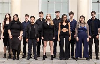 A photo of members of the Aquapella group wearing dark blue and black clothing.
