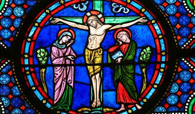 Colourful stained glass depiction of Jesus on the crucifix