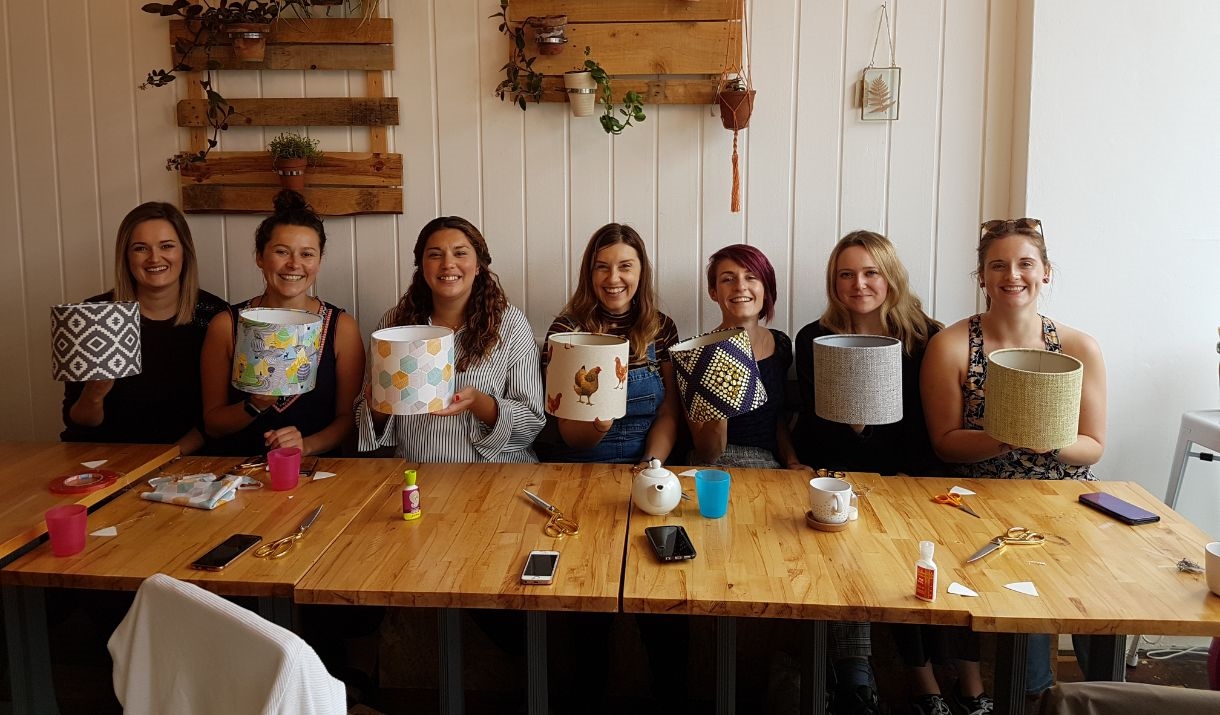 Image of ladies holding lampshades they have made