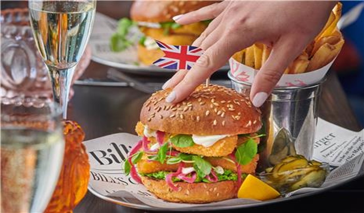 Fish burger and chips with Union Jack flag on bun.