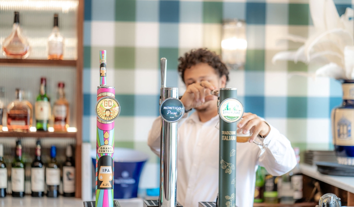 Image of person pouring a pint behind the bar