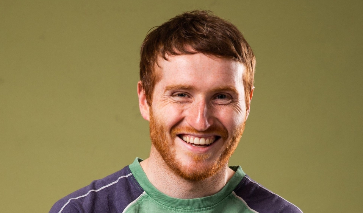A man smiling at the camera against a blank background