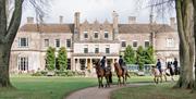 Lucknam Park exterior with people riding horses