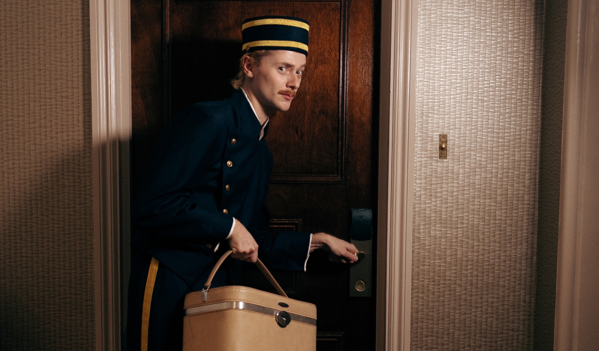 Bell boy opening a door in a hotel