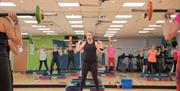 A personal trainer leading a fitness class in the gym at YMCA Bath's Health & Wellbeing Centre